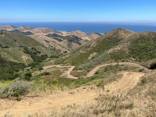 a view of a large building with mountains in the background
