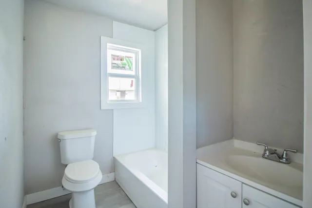 a white toilet sitting next to a bathroom sink