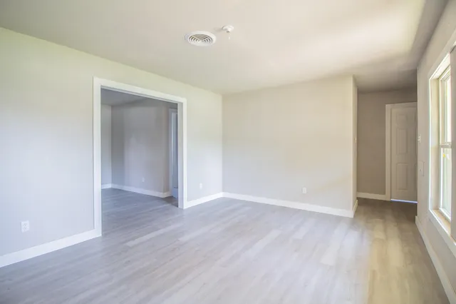 an empty room with wooden floor and closet