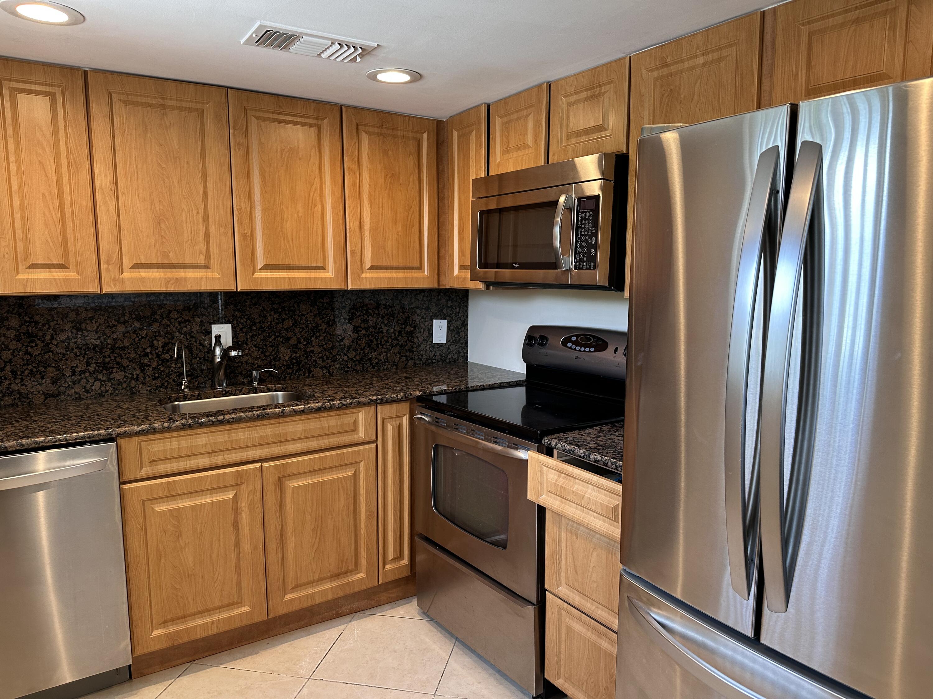 433 Saxony Way Delray Beach, FL 33446 - Photo 11 of 49 a kitchen with stainless steel appliances granite countertop a refrigerator stove and sink