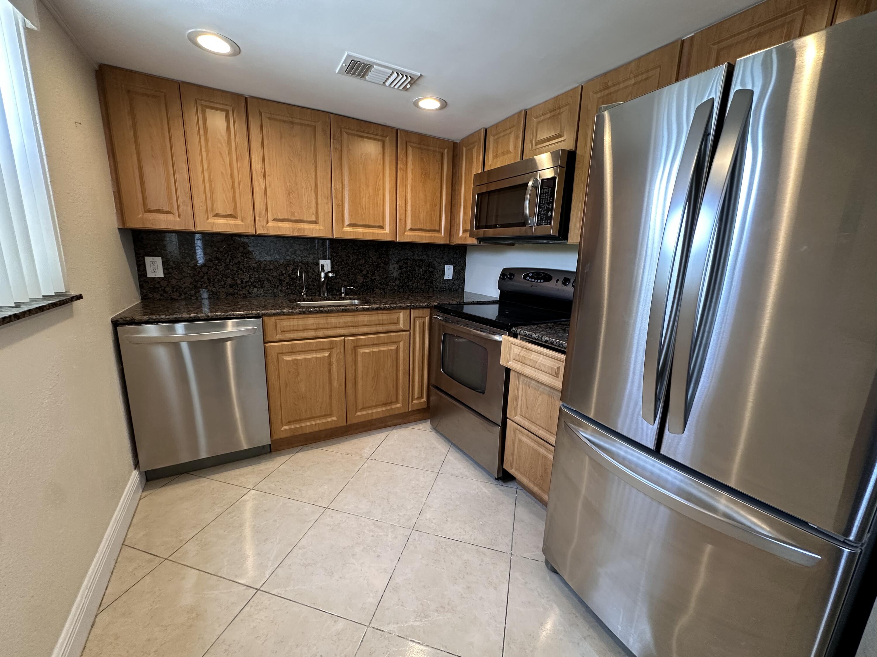 433 Saxony Way Delray Beach, FL 33446 - Photo 12 of 49 a kitchen with stainless steel appliances granite countertop a refrigerator microwave and sink