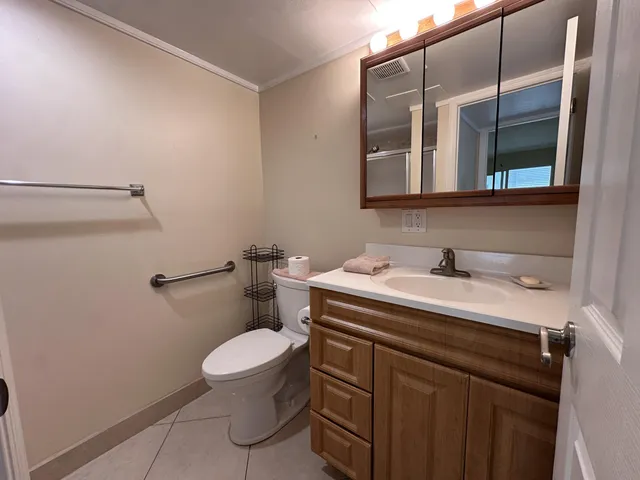 a bathroom with a granite countertop sink a toilet and a mirror
