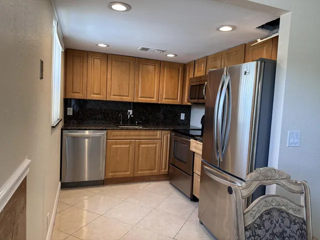 a kitchen with a refrigerator sink and cabinets