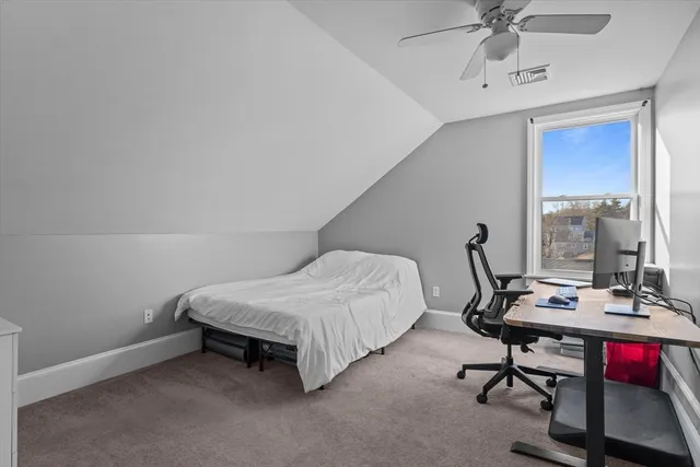 a view of a workspace with furniture and a window