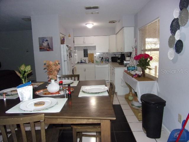 3226 Independence Avenue Lakeland, FL 33803 - Photo 7 of 19 a kitchen with sink refrigerator dining table and chairs