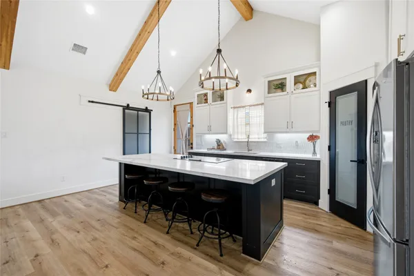 a kitchen with kitchen island a sink stove and refrigerator