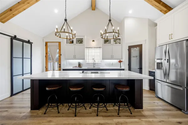 a kitchen with granite countertop a table chairs stainless steel appliances and wooden floor