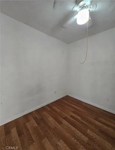 a view of a room with wooden floor and fan