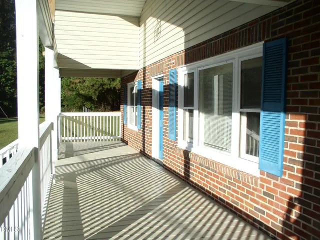 a white building with a big yard and large trees