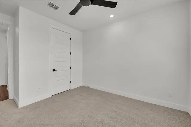 en empty room with windows and ceiling fan