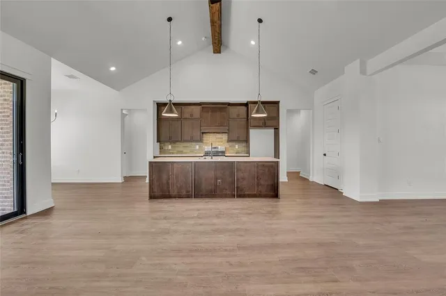 a large kitchen with kitchen island a sink stainless steel appliances and cabinets