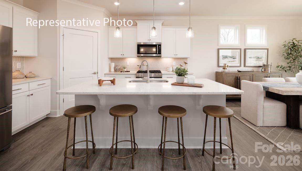4139 Round Table Drive Gastonia, NC 28056 - Photo 3 of 24 a kitchen with stainless steel appliances kitchen island granite countertop a table chairs sink and cabinets
