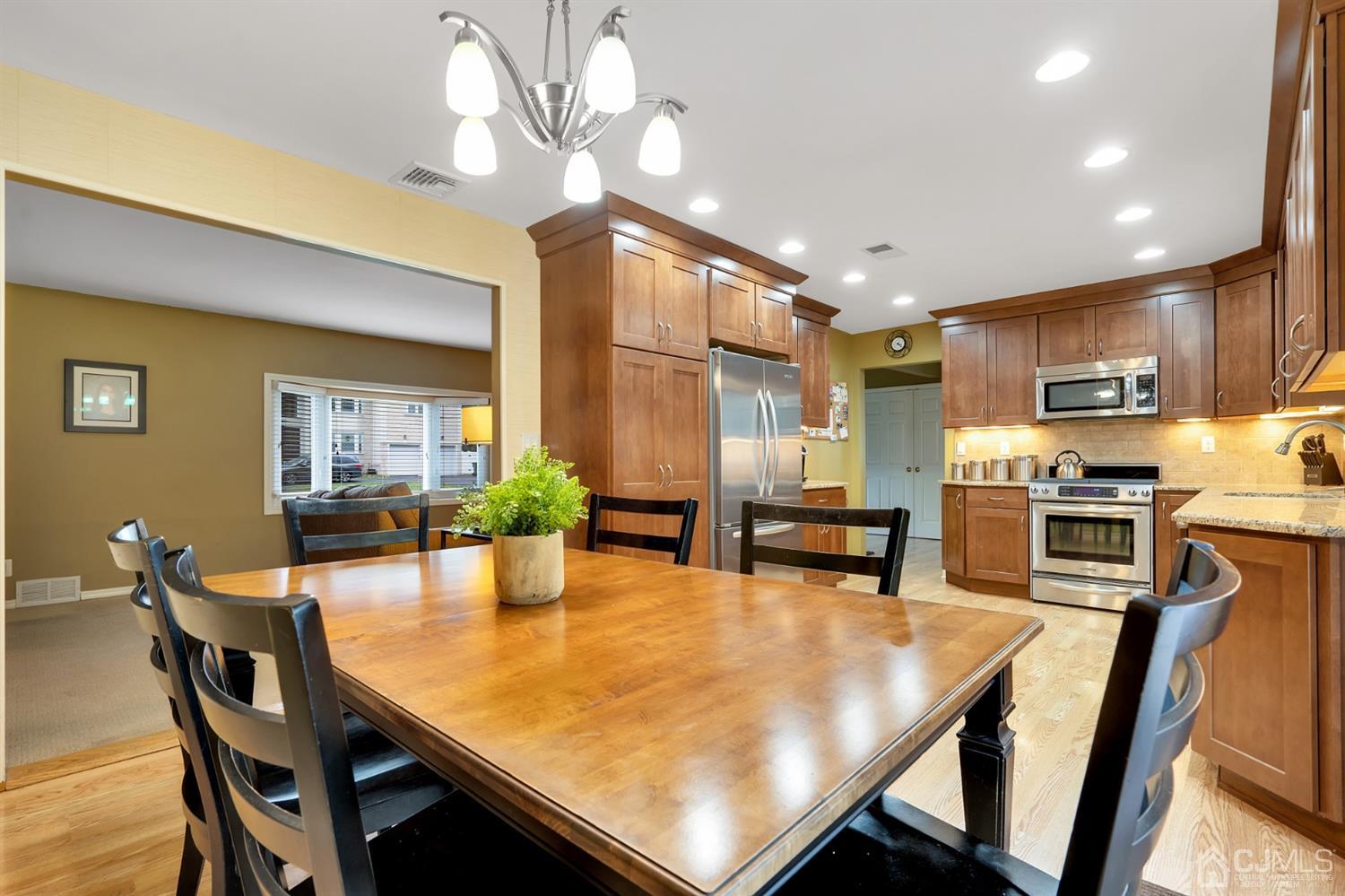 38 Homestead Road Edison, NJ 08820 - Photo 5 of 15 a kitchen with a table chairs microwave and cabinets