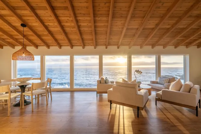 a living room with furniture and floor to ceiling windows