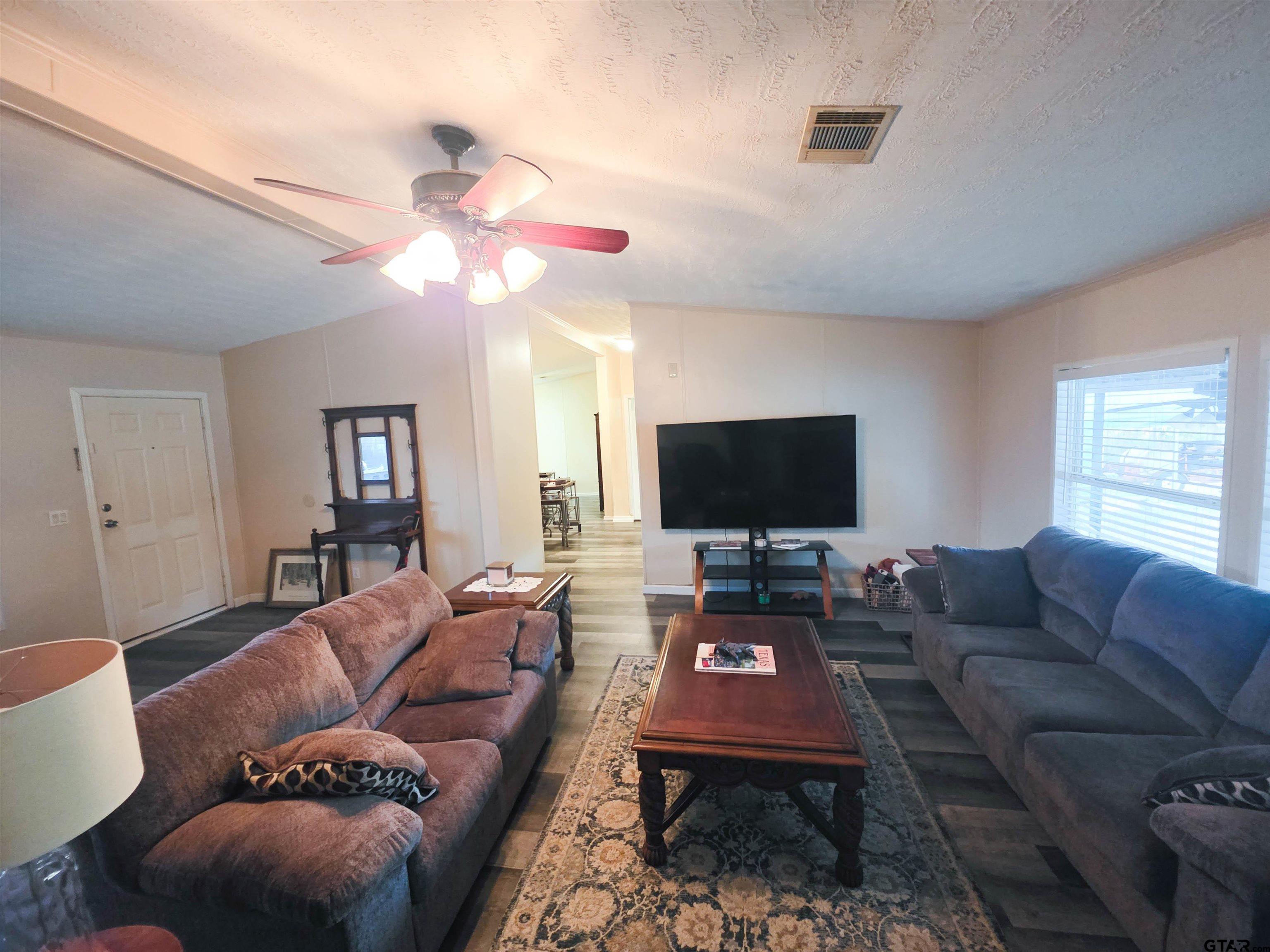 12507 Dingler Road Tyler, TX 75709 - Photo 13 of 26 a living room with furniture a flat screen tv and a window