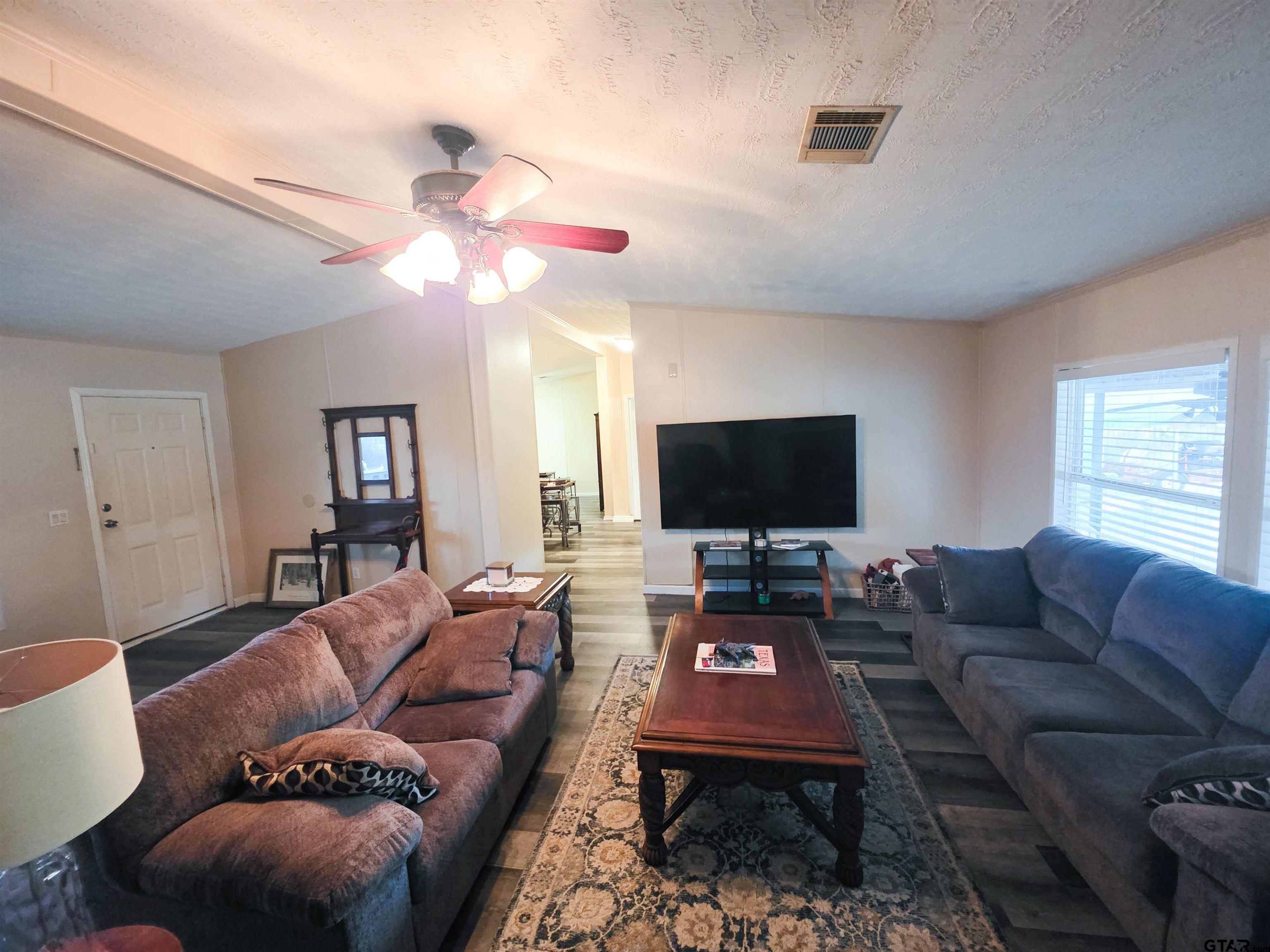 12507 Dingler Road Tyler, TX 75709 - Photo 14 of 26 a living room with furniture a flat screen tv and a window