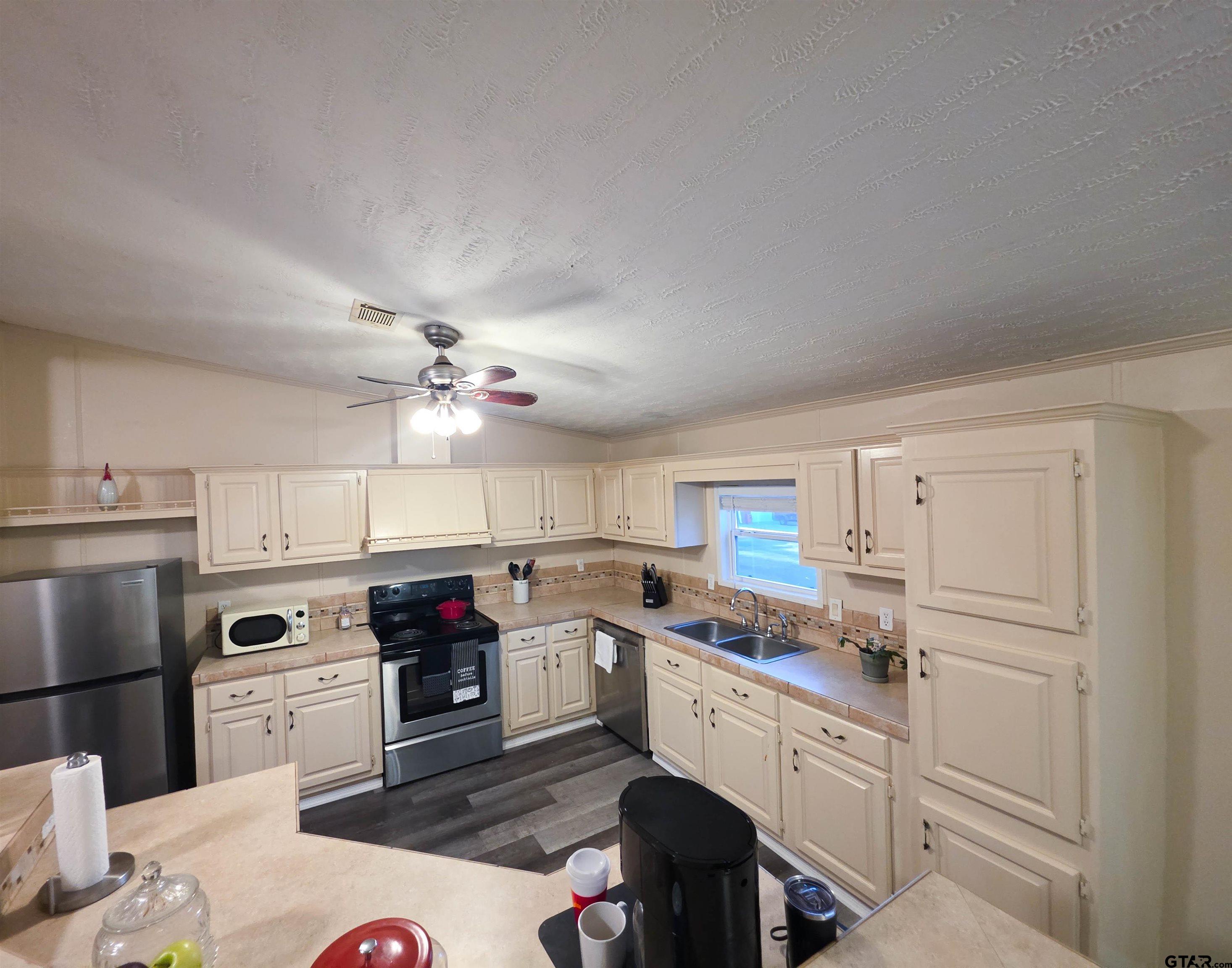 12507 Dingler Road Tyler, TX 75709 - Photo 17 of 26 a kitchen with granite countertop a sink cabinets stainless steel appliances and a window