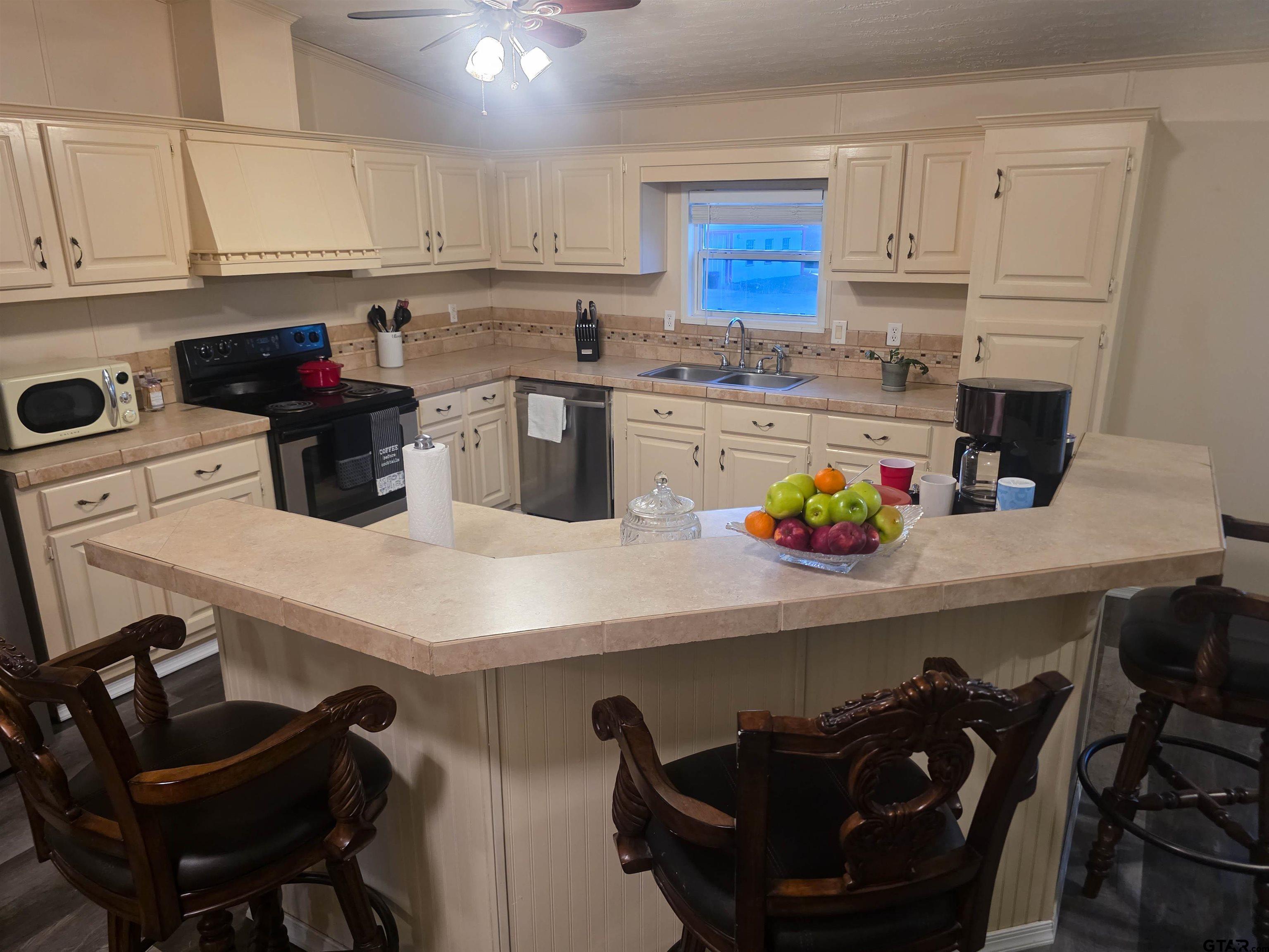 12507 Dingler Road Tyler, TX 75709 - Photo 24 of 26 a kitchen with a sink a stove and white cabinets