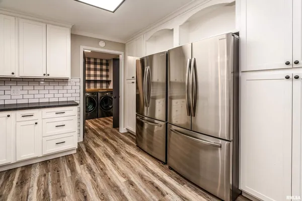 a kitchen with granite countertop stainless steel appliances a refrigerator and cabinets