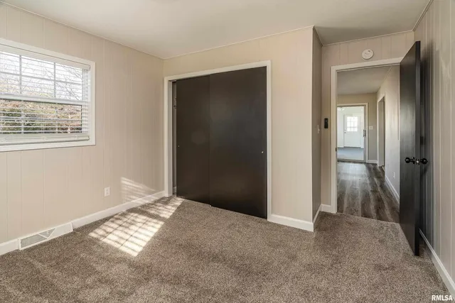 an empty room with windows and closet