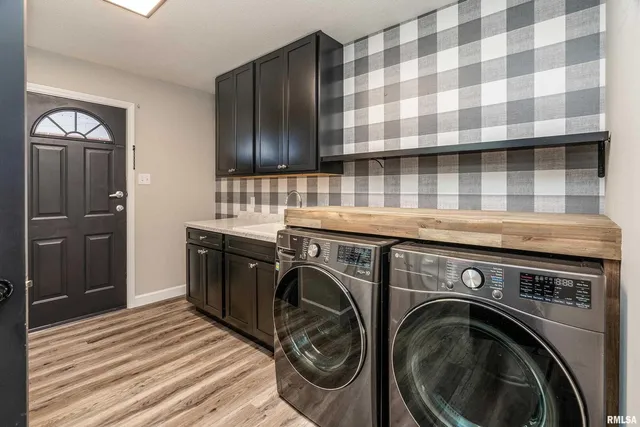 a view of a house with snow on the next to a yard with large tree