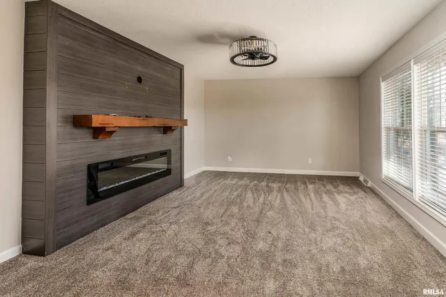 a view of an empty room with a fireplace and a window