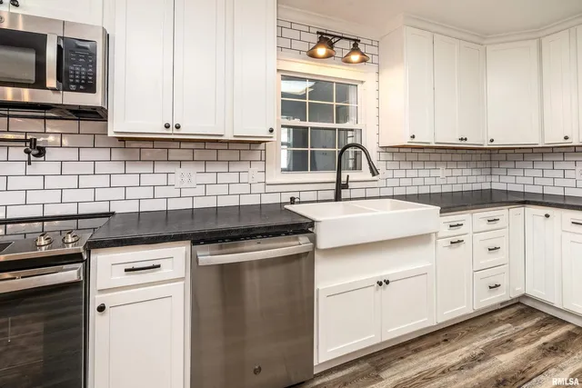a kitchen with granite countertop a sink stainless steel appliances and cabinets