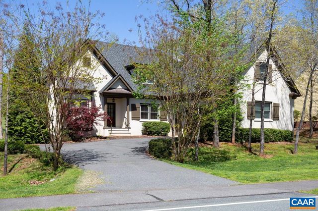 a front view of a house with a yard and potted plants