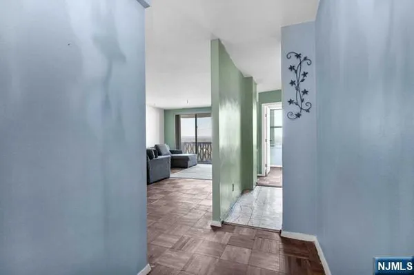 a view of a hallway with a livingroom and a bathroom with sink