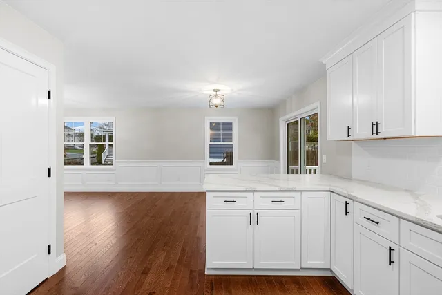 a kitchen with white cabinets and sink