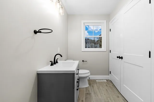 a bathroom with a sink mirror vanity and toilet