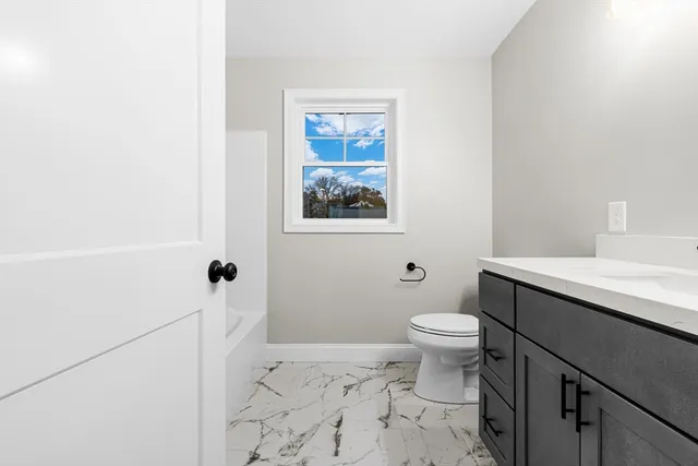 a white toilet sitting next to a bathroom sink