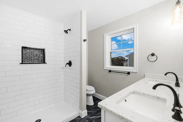 a bathroom with a sink a toilet and shower