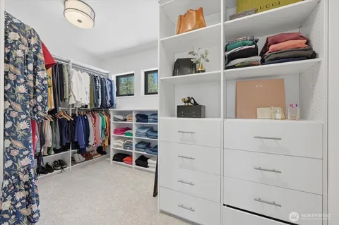 a view of walk in closet with clothes and shoes
