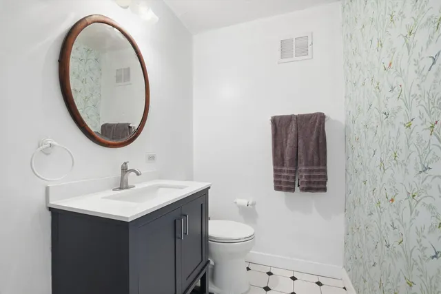 a bathroom with a sink mirror and toilet