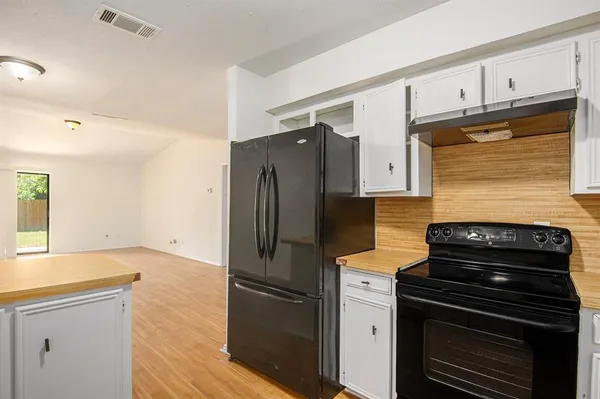 a kitchen with granite countertop a refrigerator stove and oven