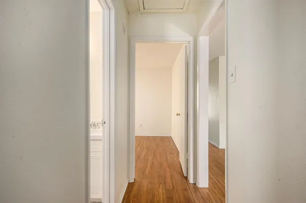 a view of a hallway with wooden floor
