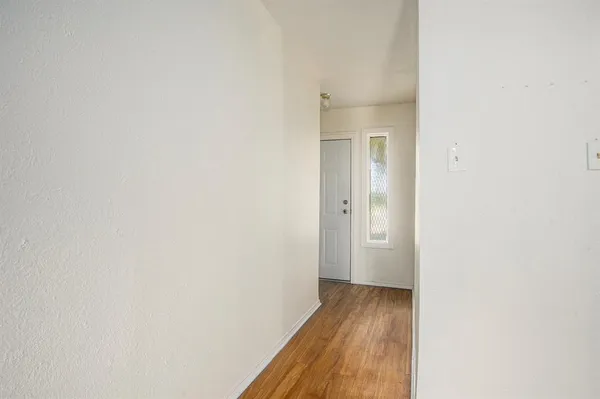 a view of a room with wooden floor and a bathroom