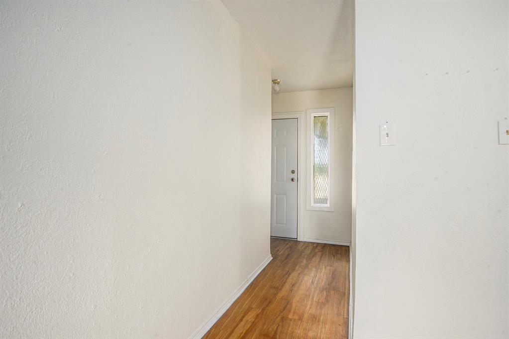 6819 West Cleburne Road Fort Worth, TX 76133 - Photo 13 of 24 a view of a room with wooden floor and a bathroom