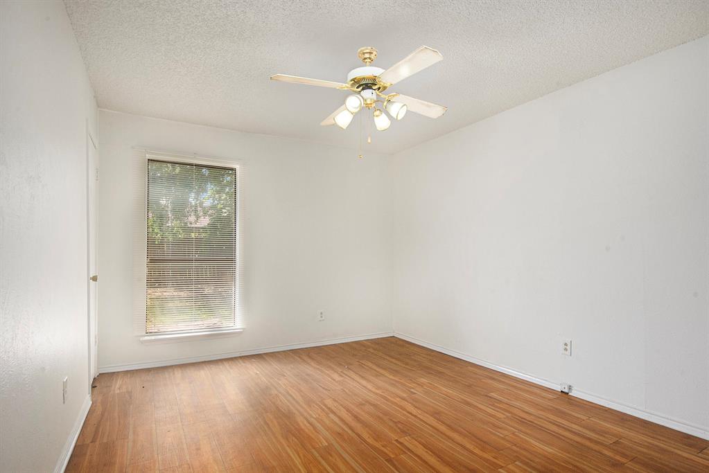 6819 West Cleburne Road Fort Worth, TX 76133 - Photo 14 of 24 a view of an empty room with wooden floor and a window