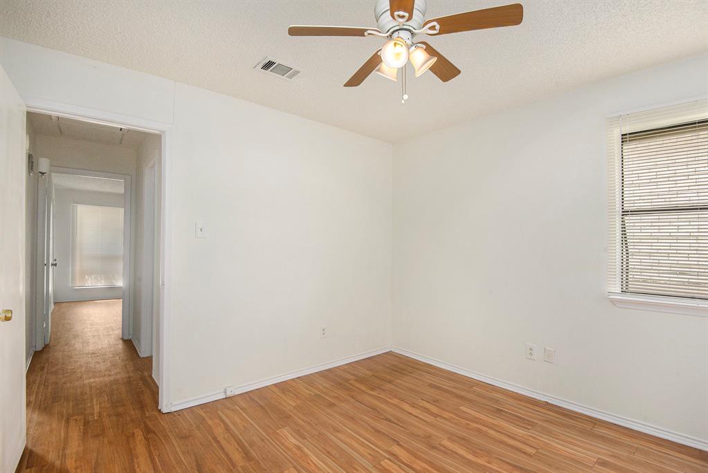 6819 West Cleburne Road Fort Worth, TX 76133 - Photo 19 of 24 wooden floor in an empty room with a window