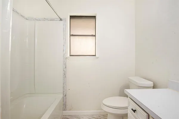 a bathroom with a toilet and a tub