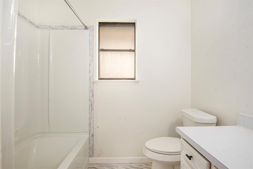 6819 West Cleburne Road Fort Worth, TX 76133 - Photo 20 of 24 a bathroom with a toilet and a tub