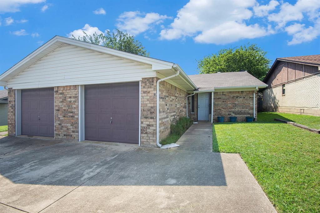 6819 West Cleburne Road Fort Worth, TX 76133 - Photo 2 of 24 a front view of a house with a yard and garage