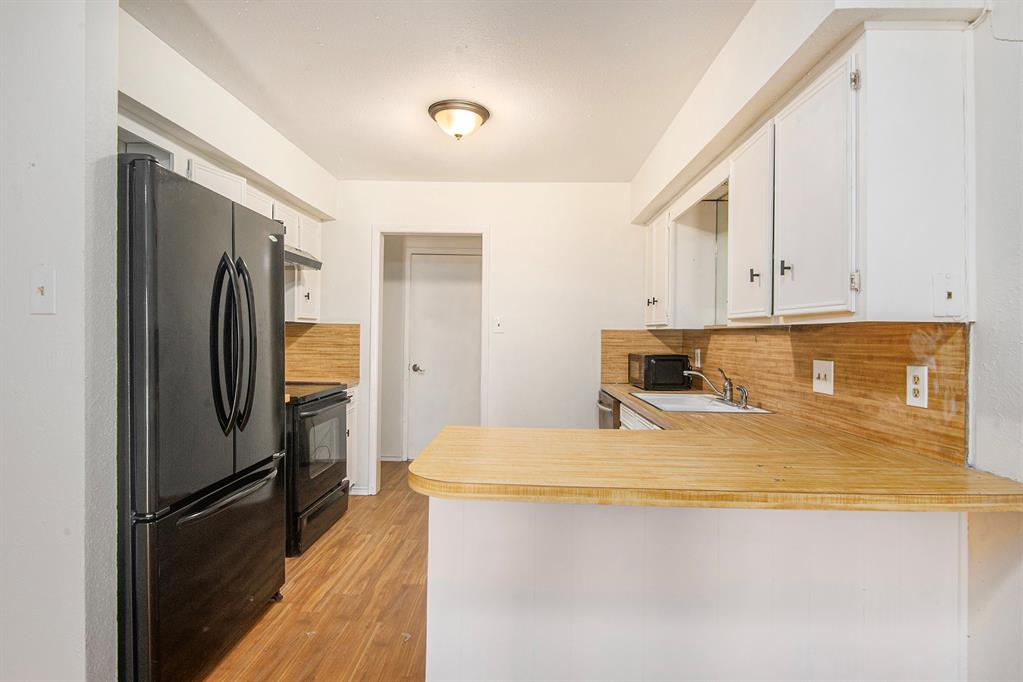 6819 West Cleburne Road Fort Worth, TX 76133 - Photo 8 of 24 a kitchen with stainless steel appliances a refrigerator and a stove