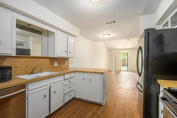 a kitchen with a sink appliances and cabinets