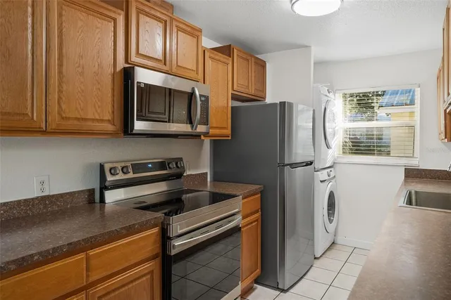 a kitchen with granite countertop a refrigerator and a stove top oven