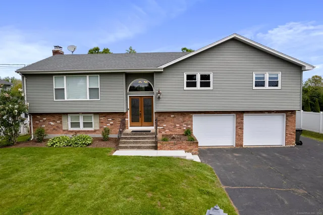 a front view of a house with a garden and yard