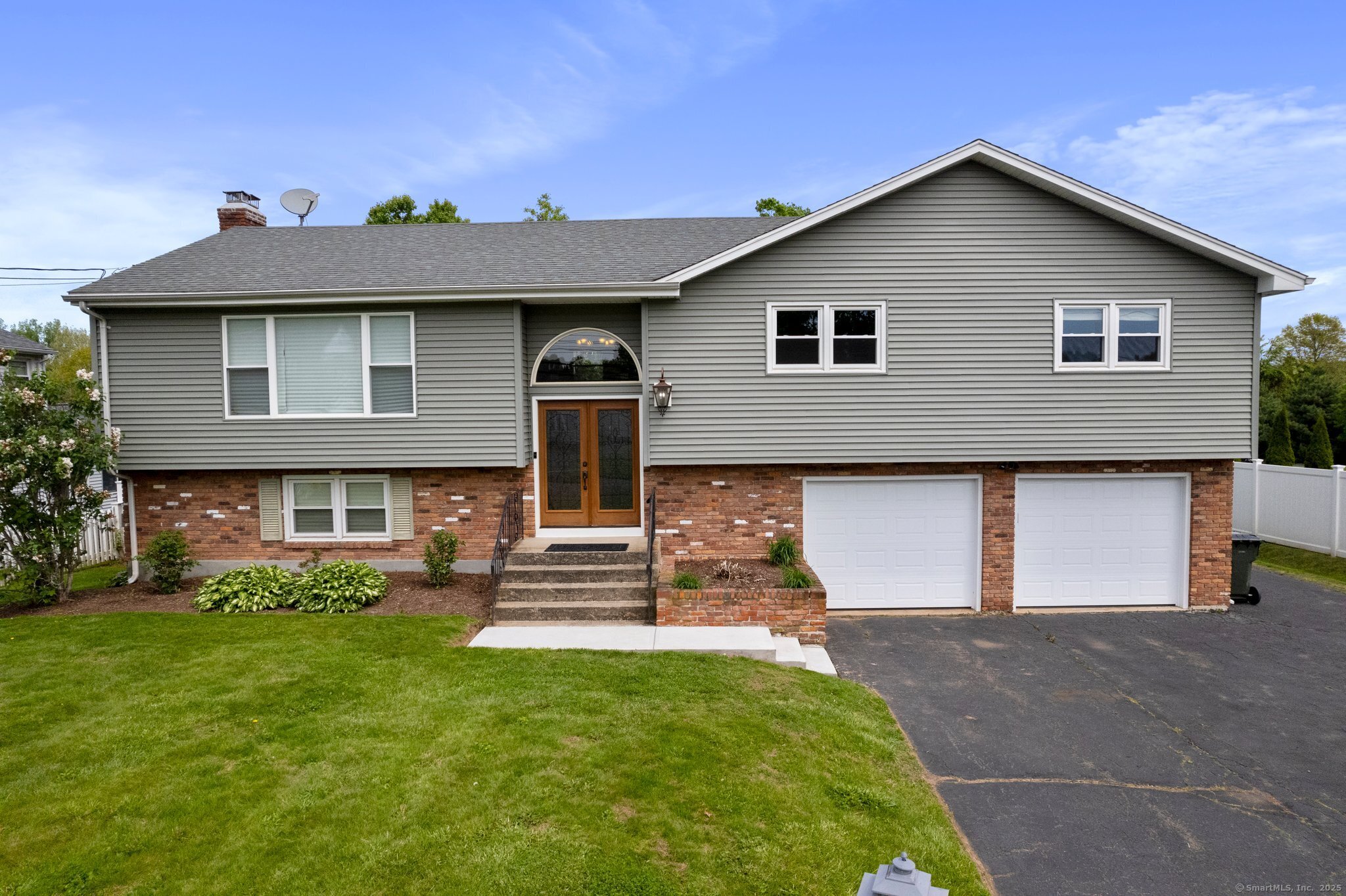 a front view of a house with a garden and yard