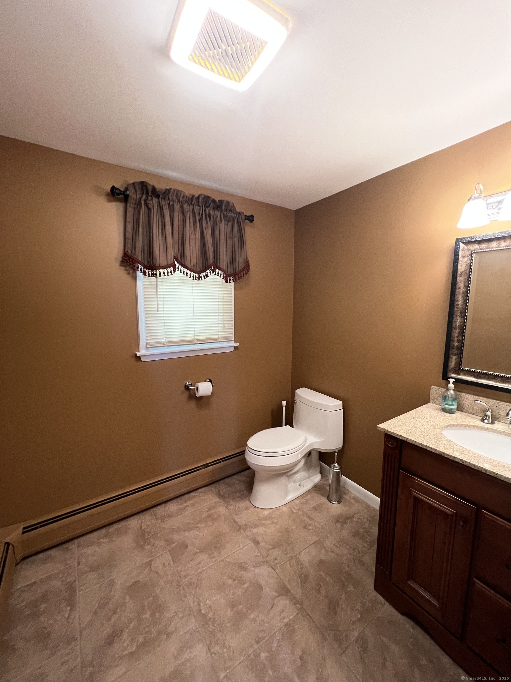 104 Willow Street Wethersfield, CT 06109 - Photo 26 of 28 a bathroom with a toilet sink and mirror